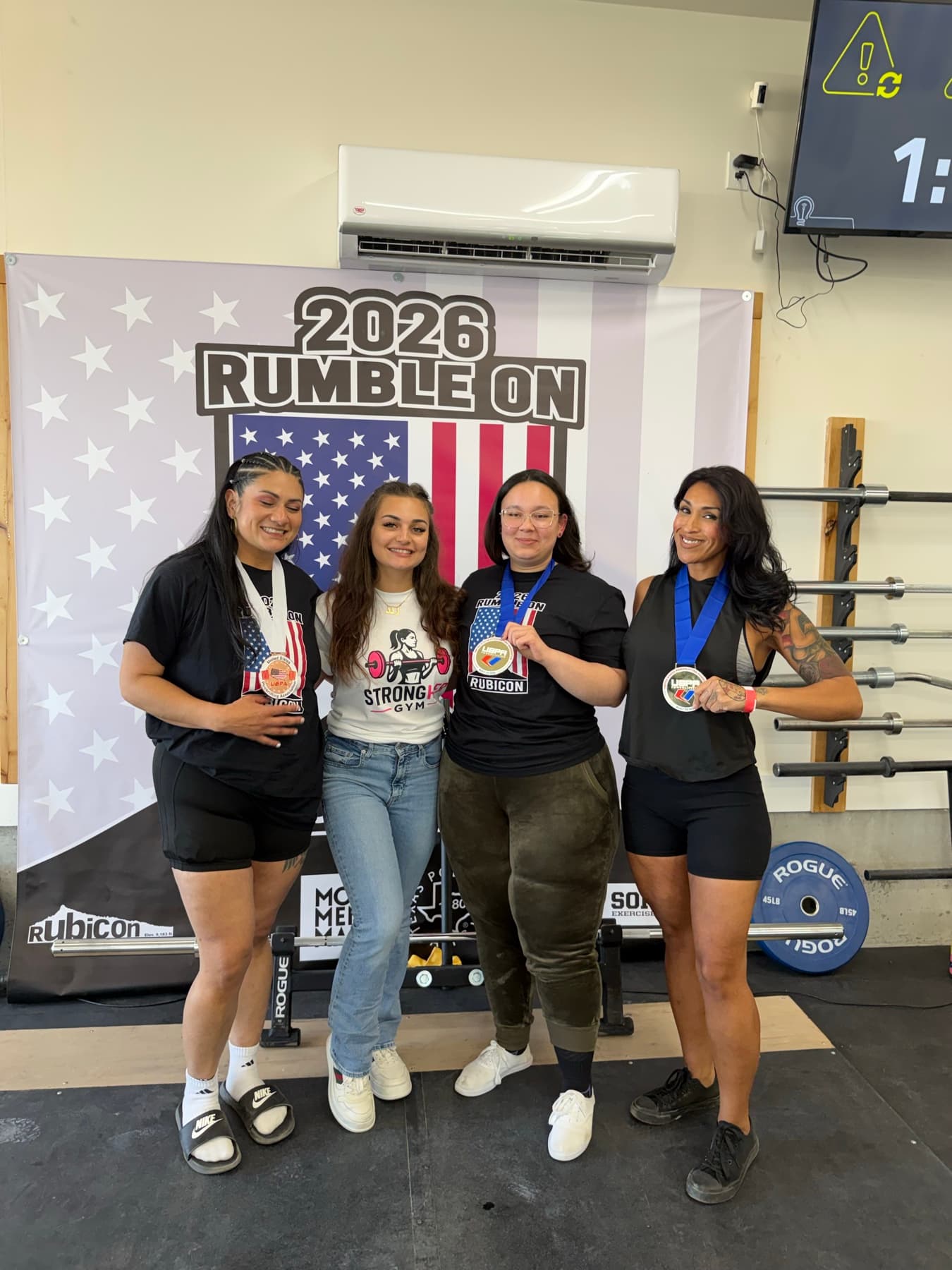 Rand with three powerlifting competitors and their medals